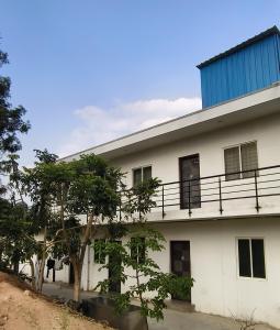 a white building with a blue roof at Elevate 1478 Inn in Nandigunda
