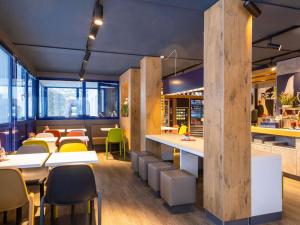 a restaurant with tables and chairs and a cafeteria at Ibis budget Hamburg Quickborn in Quickborn