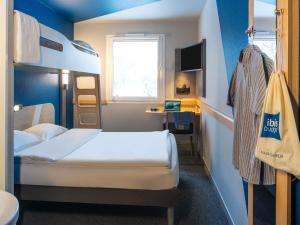 a small room with two beds and a desk at Ibis budget Hamburg Quickborn in Quickborn