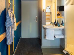 a bathroom with a sink and a mirror at Ibis budget Hamburg Quickborn in Quickborn +45 photos