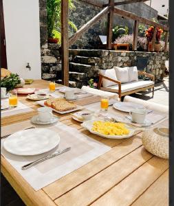 a wooden table with plates of food on it at CHC Rochinha Studio in Funchal