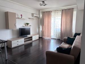 a living room with a television and a couch at Bella Home Residence2 in Roşu