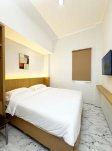 a bedroom with a white bed and a flat screen tv at Aurora House Surabaya in Wijung +18 photos