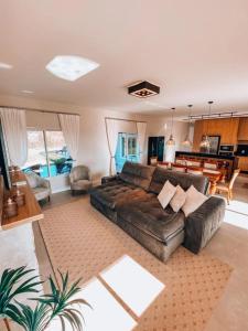 a living room with a leather couch and a table at Casa Paraíso do Sol - Rancho Queimado - SC in Rancho Queimado +56 photos