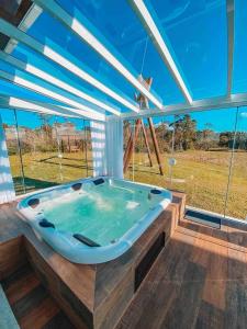 a jacuzzi tub in a house with a view at Casa Paraíso do Sol - Rancho Queimado - SC in Rancho Queimado