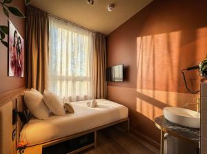 a room with a bed with a window and a sink at De Pijp Hotel in Amsterdam