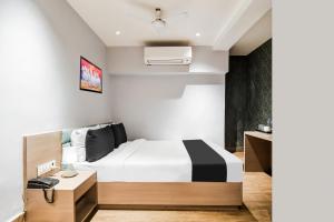 a hotel room with a bed and a desk at Hotel O Sivalika Inn in Kolkata