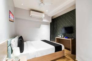 a hotel room with a bed and a tv at Hotel O Sivalika Inn in Kolkata