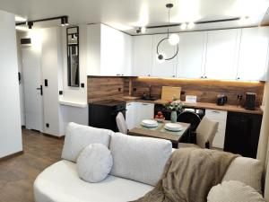 a living room with a couch and a table in a kitchen at Studio 27 in Zabrze