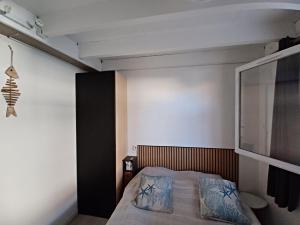 a bedroom with a bed with blue pillows on it at maison 100 m de la plage à pieds in Portiragnes