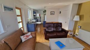 a living room with a couch and a table at Sea Drift Self Catering in Dunan