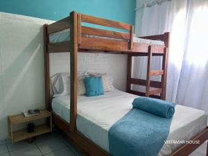 a bedroom with two bunk beds with blue pillows at Villagio Vistamar Ilha Comprida in Ilha Comprida