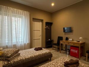 a bedroom with two beds and a desk and a window at Marbella in Ventspils