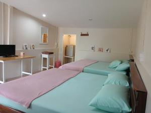 a bedroom with two beds and a desk with a computer at บ้านในสวนรีสอร์ทBannnaisuan Resort in Prachuap Khiri Khan