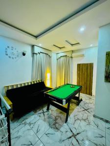 a living room with a pool table and a couch at The Cape - Apartment in Bamgbose