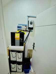 a room with a microwave and acomputer on a shelf at The Cape - Apartment in Bamgbose