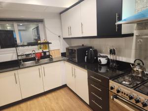a kitchen with white cabinets and a sink and a microwave at Shahan Residence in Muscat +36 photos