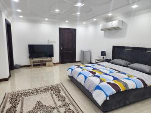 a bedroom with a large bed and a flat screen tv at Shahan Residence in Muscat