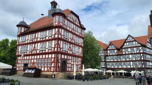 a large red and white building with a clock tower at Pension Melsungen in Melsungen