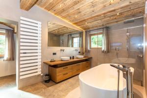 a bathroom with a tub and a shower and a sink at Hauserhof- Urlaub am Bauernhof inklusive Sommercard in Bramberg am Wildkogel +26 photos