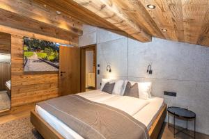 a bedroom with a large bed and wooden ceilings at Hauserhof- Urlaub am Bauernhof inklusive Sommercard in Bramberg am Wildkogel