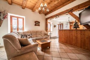 a living room with a couch and a tv at La Ferme de Sous-Lachat in Samoëns