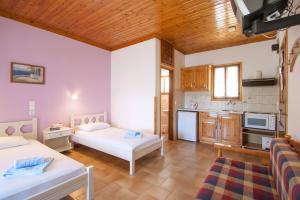 a living room with two beds and a kitchen at Angela studios in Troulos +26 photos