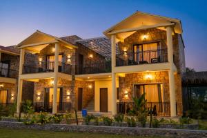 a large house with lights on the facade at Achal Bagh - Boutique Stay Abu Road in Māwāl +10 photos