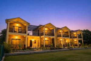 a large house with lights on it at night at Achal Bagh - Boutique Stay Abu Road in Māwāl