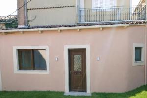 ein Haus mit einer braunen Tür und zwei Fenstern in der Unterkunft maison jamouri in Kríni