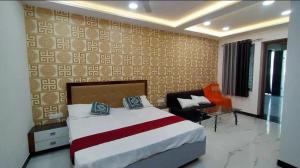 a hotel room with a bed and a chair at Hotel Jms Inn in Agra