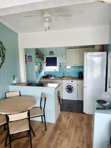 a kitchen with a table and a white refrigerator at Pensilva in Hayle