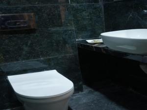 a bathroom with a white toilet and a sink at Royal Milestone Resort & Hotel in Gwalior