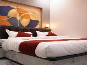 a bedroom with a large bed with red and white pillows at Royal Milestone Resort & Hotel in Gwalior
