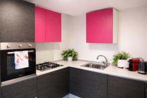 a kitchen with pink cabinets and a sink at Villa Pineta Grande in Lignano Sabbiadoro +26 photos