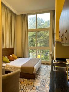 a bedroom with a bed and a large window at Mar Mkhayel Studios in Beirut
