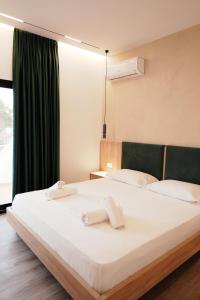 a bedroom with a large white bed with a window at Villa SOLIS in Vlorë