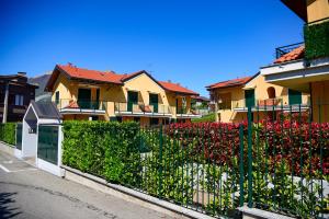 a fence in front of some houses with red flowers at Bellagio Breva in Bellagio