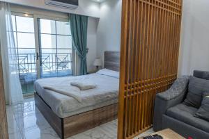 a bedroom with a bed and a couch and a chair at Juliana Beach Hurghada in Hurghada +81 photos
