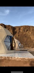 two tents sitting on the side of a mountain at The Martian Bubbles - Wadi Rum in Wadi Rum