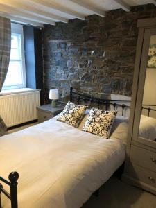a bedroom with a large bed with a stone wall at Cosy Pubs Bed & Breakfast in Rhayader
