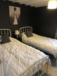 two beds in a room with black walls at Cosy Pubs Bed & Breakfast in Rhayader