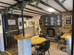 a restaurant with tables and chairs and a brick wall at Cosy Pubs Bed & Breakfast in Rhayader