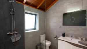a bathroom with a toilet and a sink and a window at Casa da Felicidade by LovelyStay in Prazeres +43 photos