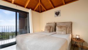 a bedroom with a bed and a large window at Casa da Felicidade by LovelyStay in Prazeres
