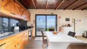 a kitchen with a large white table with chairs at Casa da Felicidade by LovelyStay in Prazeres
