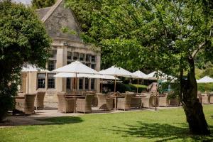a group of chairs and umbrellas in front of a building at The Hare & Hounds Hotel in Tetbury