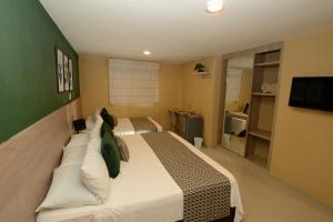 a bedroom with a large bed with pillows at Hotel Prado 34 West in Bucaramanga