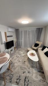a living room with a couch and a table at Апартамент Зора in Chepelare