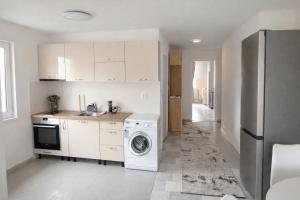 a kitchen with a washing machine and a refrigerator at Апартамент Зора in Chepelare